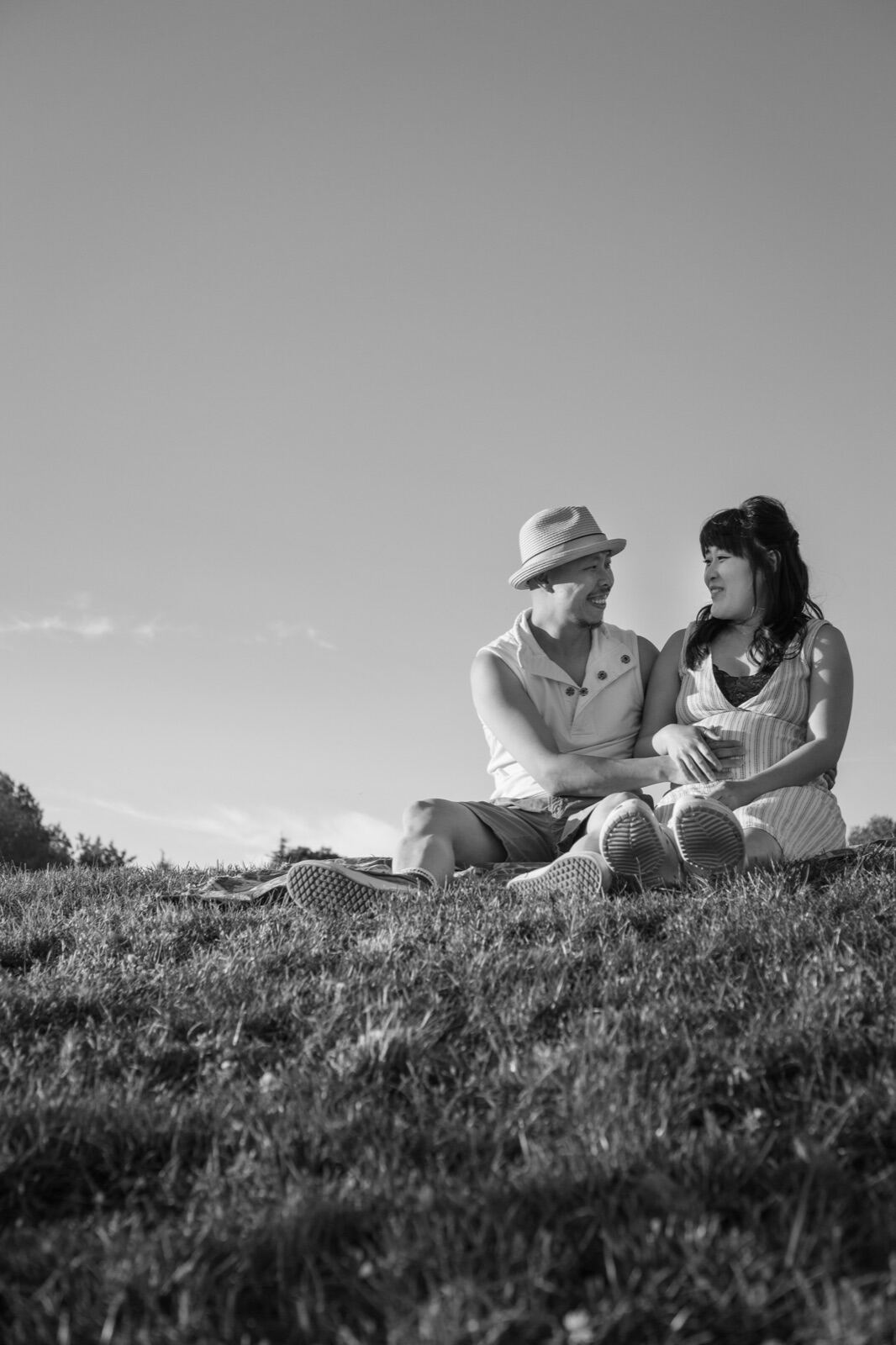 Couple sitting together on a hillside, in black and white