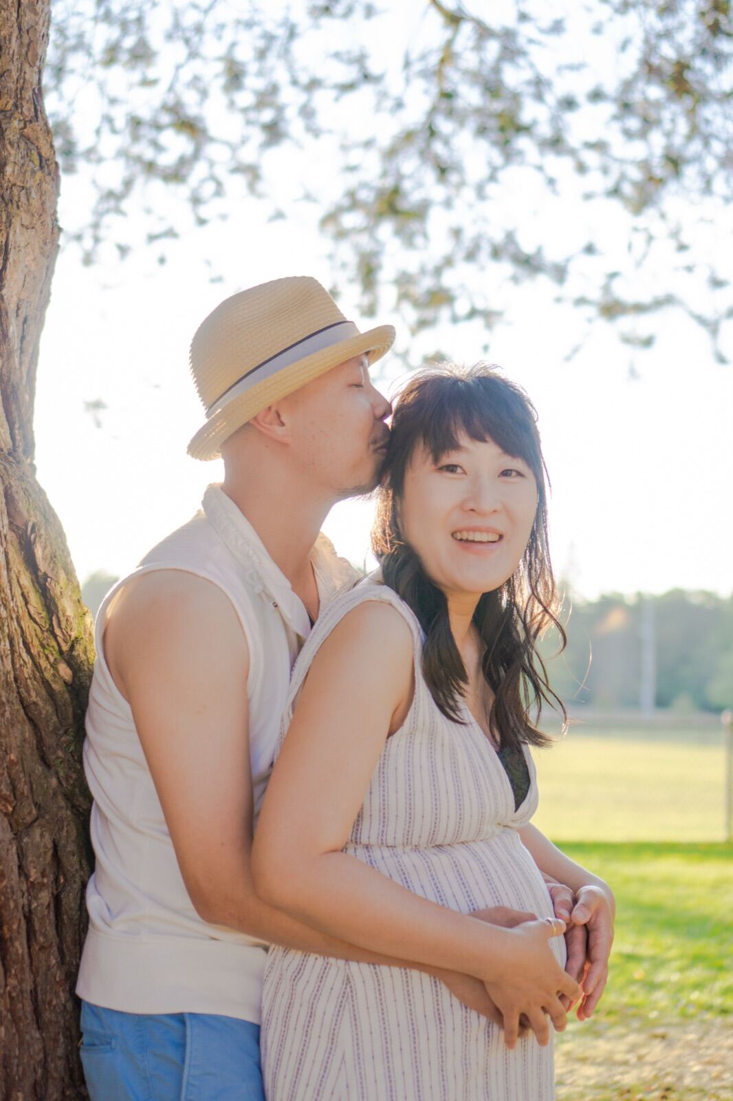 Couple embracing beneath a tree in the park