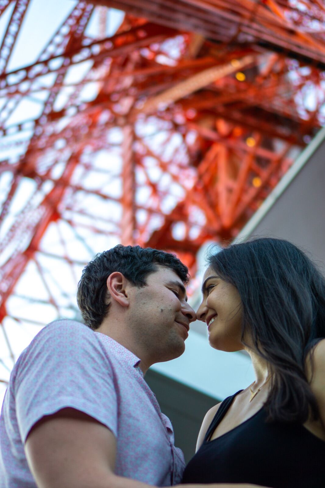 Couple beneath the tower, almost kissing