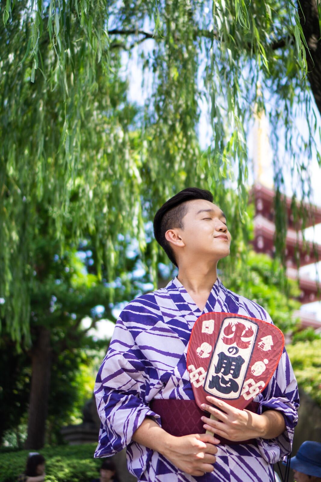Quiet yukata portrait beneath willow branches