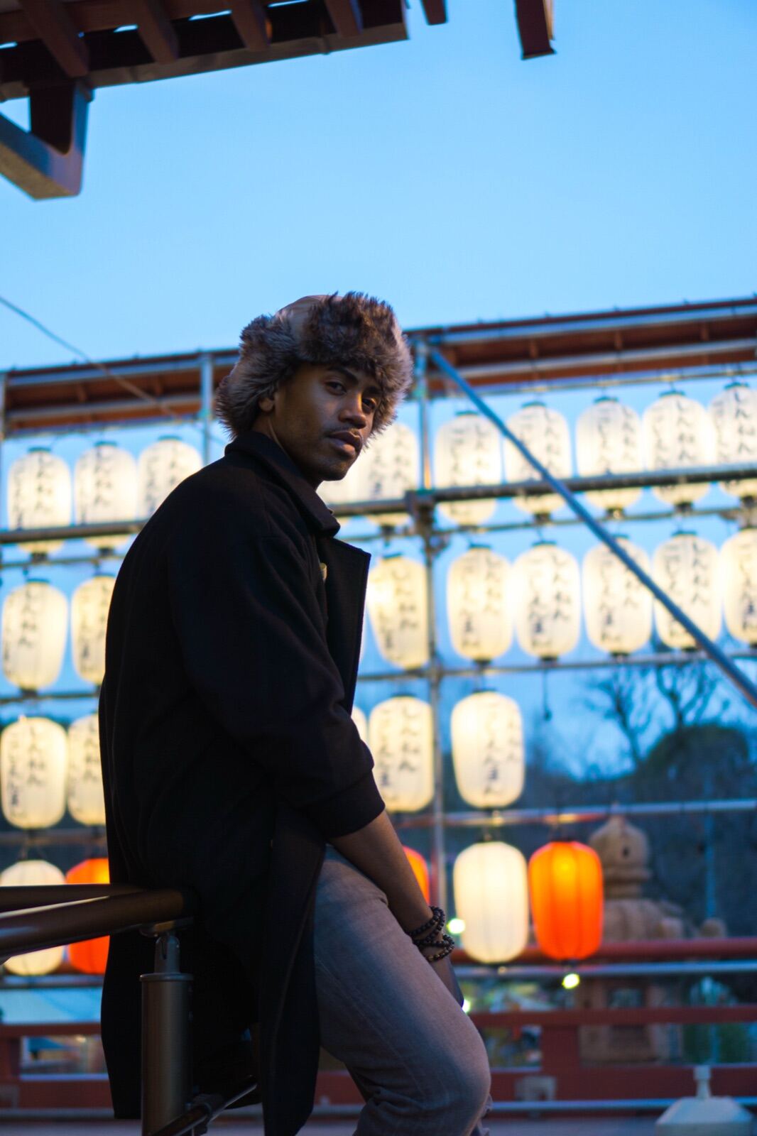 Portrait framed by lantern light at dusk